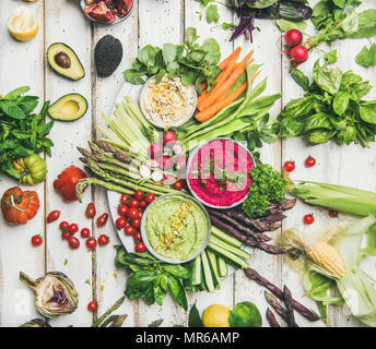 Raw vegan sain d'été. Télévision à jeter du pois chiche, betterave, épinard de l'hoummos dips avec des légumes colorés et des verts sur la table en bois blanc backgrou Banque D'Images