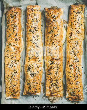 Télévision à jeter de Borek turc rouleaux aux épinards, fromage feta et les graines de cumin noir sur la plaque de cuisson, vue du dessus. Medi est traditionnel Banque D'Images