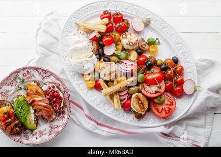 Salade piquante et fraîche avec des tomates et mozzarella fromage servi sur un plateau avec des épices Banque D'Images