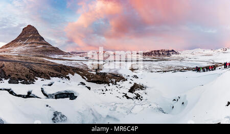Kirkjufell mountain, Kirkjufellfoss congelés cascade en face, ciel nuageux avec coucher du soleil, l'ouest de l'Islande, fjord Grundarfjördur Banque D'Images