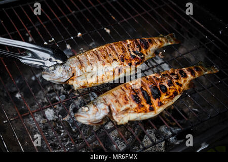 Man grilling poisson grillé dans la rue pour un événement Man grilling poisson grillé dans la rue pour un événement