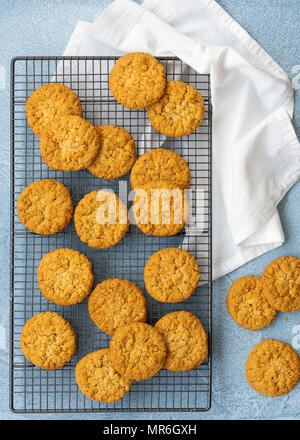 Biscuits à l'avoine et miel sur une grille de refroidissement sur un fond bleu. Banque D'Images