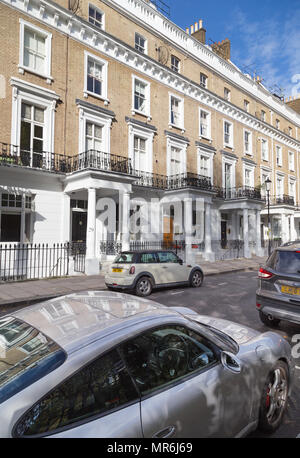 La façade en stuc maisons mitoyennes dans le quartier chic de Onslow Gardens, London, UK, lors d'une journée ensoleillée avec une voiture de sport en premier plan Banque D'Images