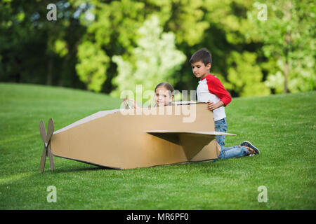 Adorables petits enfants jouant avec un carton avion dans Green Park Banque D'Images