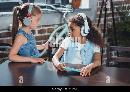 Choqué african american girl in headphones regardant ami debout près de par Banque D'Images