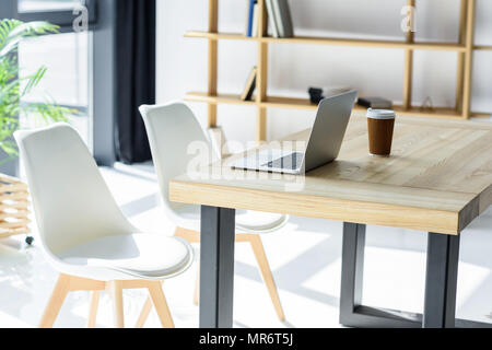 Ordinateur portable et coffe cup on table in modern office Banque D'Images