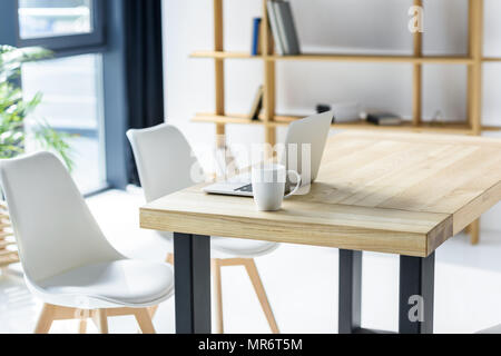 Ordinateur portable et coffe cup on table in modern office Banque D'Images