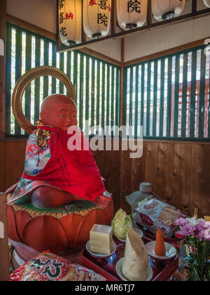 Statue Jizo Bosatsu avec dossard rouge et les offrandes, Koyasan, Wakayama, Japon Banque D'Images