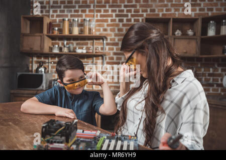 Petit-fils et sa mère à l'un l'autre sur des lunettes teintées Banque D'Images