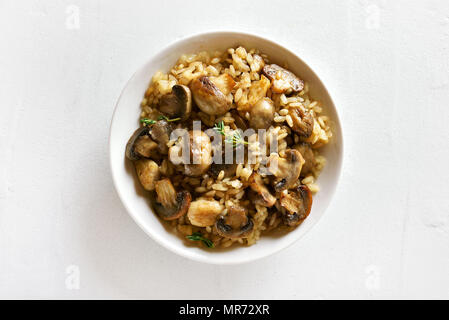 Délicieux risotto aux champignons et morceaux de viande de poulet sur fond noir en blanc. Haut de la vue, télévision lay Banque D'Images