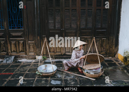 HOI AN, VIETNAM - 03 janvier, 2018 : vietnamese woman selling food sur rue dans Hoi An, Vietnam Banque D'Images