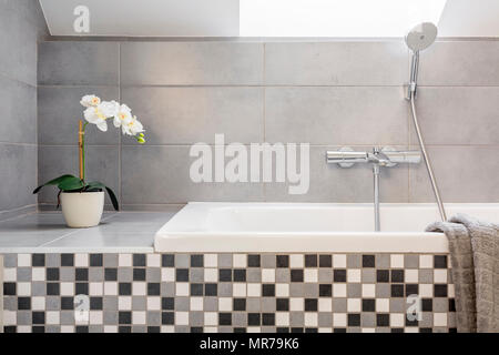 Salle de bains gris avec des carreaux de mosaïque et d'une baignoire Banque D'Images