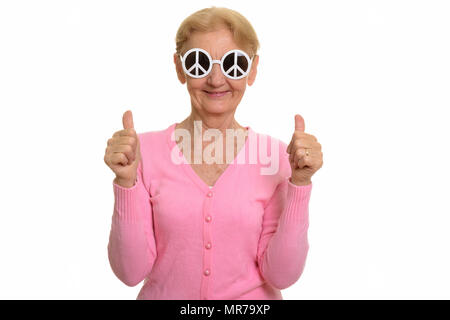 Happy senior woman smiling tout en portant des lunettes de soleil avec la paix s Banque D'Images