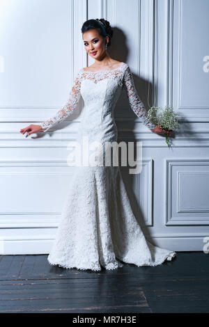 Jeune femme en robe blanche avec des fleurs fashion portrait Banque D'Images