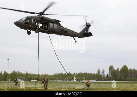 Les soldats de l'Opérations spéciales (FOS) Quitter un UH-60 Black Hawk de la compagnie C du bataillon d'hélicoptères d'assaut, 2-10, 10e Brigade d'aviation de combat, au cours d'une extraction et d'insertion de la corde rapide (frites) Formation à Lielvarde, la Lettonie, le 17 mai. La brigade et membres de la SOF lettons ont travaillé ensemble pendant une semaine entière à se qualifier pour les compétences à l'insertion de troupes d'élite des techniques telles que la ligne statique, parachutes, militaire en chute libre et des frites. (U.S. Photo de l'armée par la CPS. Thomas Scaggs) 170517-A-TZ475-303 Banque D'Images