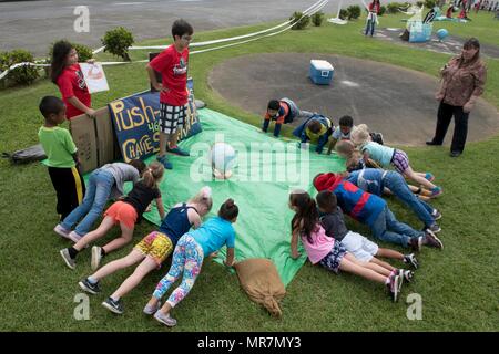 Les enfants de l'école élémentaire Kadena pushup pratique comme une activité éducative 22 mai 2017, à Kadena Air Base, au Japon. Divers stands d'éducation ont été mis en place par le programme d'anglais langue seconde à faire preuve d'un certain nombre de records mondiaux, tels que les la plupart des pompes réalisés dans un délai de 24 heures, ce qui est 46 001. (U.S. Photo de l'Armée de l'air par les cadres supérieurs d'un membre de la John Linzmeier) Banque D'Images