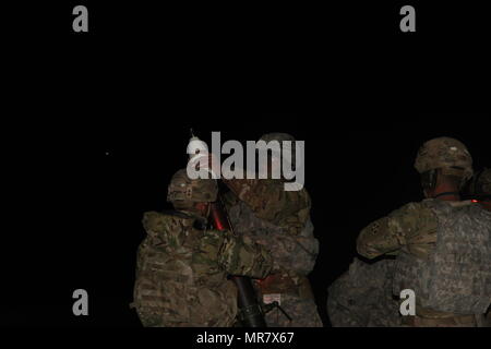 Au milieu de la nuit, les soldats du peloton de mortiers et siège de l'entreprise de l'Administration centrale, 2e Bataillon, 12e Régiment d'infanterie, 2e Brigade Combat Team, 4e Division d'infanterie, chargement d'un cycle d'éclairage dans un mortier pour éclairer la voie pour leurs camarades de manoeuvres dans la forêt ci-dessous, le 24 mai 2017 à Grafenwoehr Secteur d'entraînement, de l'Allemagne. Tours d'éclairage fournir de meilleurs visuels pour les unités d'infanterie légère dans la nuit comme ils s'engager un ennemi, et de mortier sont également capables de transporter des explosifs et des coquilles de fumée adapté pour fournir la dissimulation. (Photo prise par Pvt. Nicholas Vi Banque D'Images