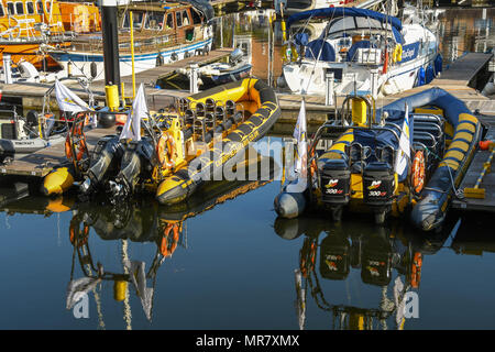 Bateaux à grande vitesse à quai à Penarth Marina avec reflets dans l'eau encore in early morning light Banque D'Images