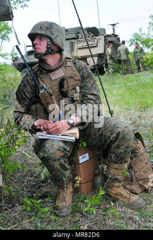 Lance le Cpl. Benjamin Schultz, un Marine d'appui-feu Naval Air avec 3e Compagnie de liaison de Bell Gardens, en Californie, reçoit des informations de suivi bataille pendant l'exercice Maple résoudre 17 au Camp Wainwright, Alberta, Canada, le 23 mai 2017. Il travaillait avec 2 Royal Canadian Regiment sur une mission de reconnaissance au cours de l'Armée canadienne à l'échelle de la brigade de premier exercice de validation 14-29 mai. (U.S. Photo de l'armée par le Sgt. Sarah Zaler) Banque D'Images