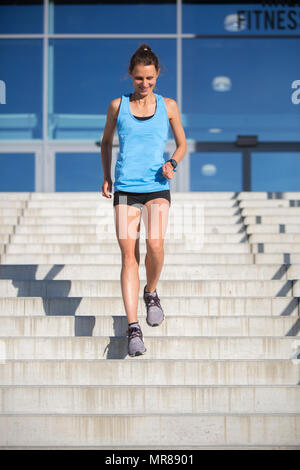 Femme athlète courir dans les escaliers Banque D'Images