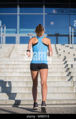 Femme athlète courir vers le haut de l'escalier Banque D'Images