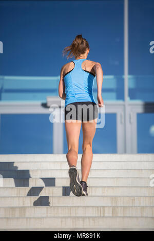 Femme athlète courir vers le haut de l'escalier Banque D'Images