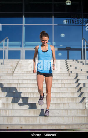 Femme athlète courir dans les escaliers Banque D'Images