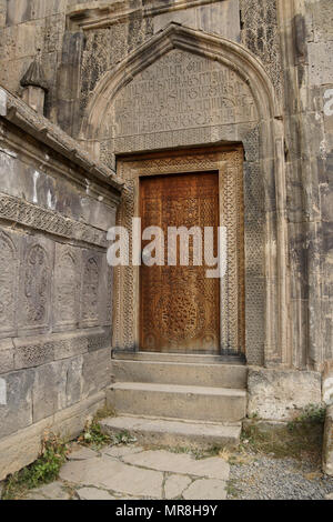 Une porte de bois finement sculptée mène au 9ème siècle de l'église Surp Poghos-Petros (St. Paul et Saint Pierre) au monastère de Tatev, en Arménie. Banque D'Images