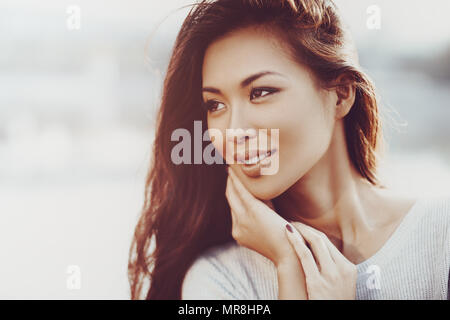 Young Asian woman outdoors portrait dans des couleurs chaudes Banque D'Images