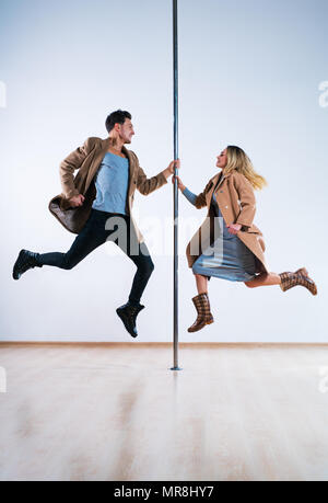 Jeune homme et femme pôle de danseurs occasionnels vêtements automne en sautant Banque D'Images