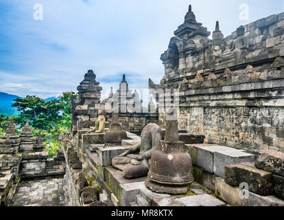 Statues de Bouddha assis sur une balustrade du 9e siècle Borobudur temple bouddhiste, le centre de Java, Indonésie Banque D'Images