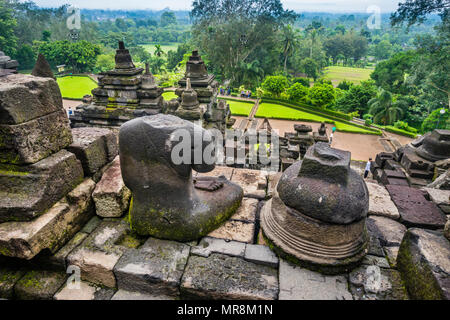 Une statue du Bouddha sans tête à la balustrade du 9e siècle Borobudur temple bouddhiste, le centre de Java, Indonésie Banque D'Images