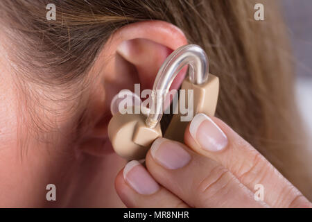 Photo en gros plan de femme portant une aide auditive Banque D'Images