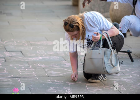 Une femme écrit des messages à la craie sur le trottoir à St Ann's Square avant le concert Concert de Manchester se souvenir des victimes de l'arène à la bombe à Manchester, Angleterre, le 22 mai 2018. Le prince William et le Premier ministre britannique Theresa peuvent se joindre à d'autres politiciens, ainsi que les membres de la famille de ceux qui ont été tués, et les premiers intervenants sur les lieux de l'attaque terroriste, alors que des milliers de personnes se sont réunies à Manchester mardi sur le premier anniversaire d'une attaque terroriste dans la ville qui a laissé 22 morts. Banque D'Images