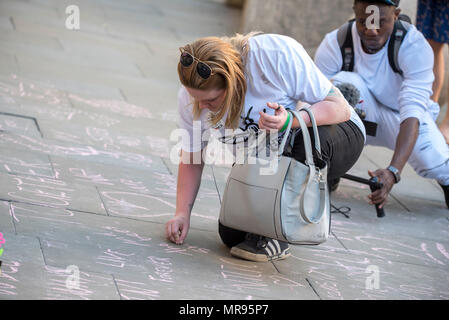 Une femme écrit des messages à la craie sur le trottoir à St Ann's Square avant le concert Concert de Manchester se souvenir des victimes de l'arène à la bombe à Manchester, Angleterre, le 22 mai 2018. Le prince William et le Premier ministre britannique Theresa peuvent se joindre à d'autres politiciens, ainsi que les membres de la famille de ceux qui ont été tués, et les premiers intervenants sur les lieux de l'attaque terroriste, alors que des milliers de personnes se sont réunies à Manchester mardi sur le premier anniversaire d'une attaque terroriste dans la ville qui a laissé 22 morts. Banque D'Images