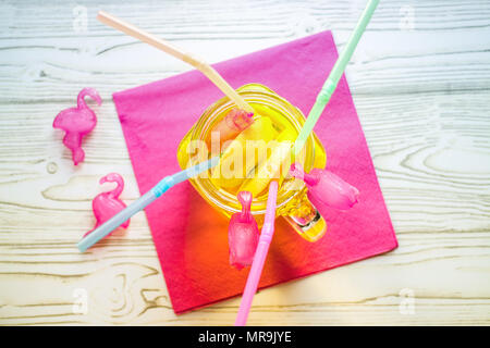 Limonade glacée dans un bocal en verre avec paille et glacées des flamants roses en plastique Banque D'Images