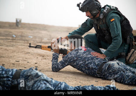 Un Guardia Civil espagnole formateur mains un magazine à des membres de forces de sécurité irakiennes au cours de formation au tir à courte portée à la gamme Besmaya complexe, l'Iraq, le 23 mai 2017. Cette formation fait partie de la Force opérationnelle interarmées combinée globale - Fonctionnement résoudre inhérent à renforcer les capacités des partenaires mission par la formation et de l'amélioration de la capacité des forces des combats en partenariat avec ISIS. Les GFIM-OIR est la Coalition mondiale pour vaincre ISIS en Iraq et en Syrie. (U.S. Photo de l'armée par le Cpl. Tracy McKithern) Banque D'Images