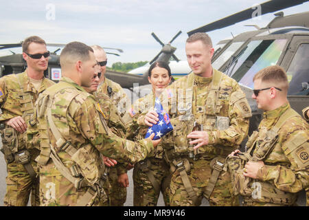 Le capitaine Joel Castro (présentateur) et les soldats affectés à 2e Bataillon d'hélicoptères d'assaut, 82e Brigade d'aviation de combat présente le lieutenant-colonel Travis McIntoch, commandant de 2-82ème cabine, avec un pavillon replié comme un hommage à son dernier vol dans le 82e et de la cabine à son service désintéressé comme un chef de bataillon à Concord Aéroport régional, Concord, NC, le 28 mai. (U.S. Photo de l'armée par le Sgt. Steven Galimore) Banque D'Images