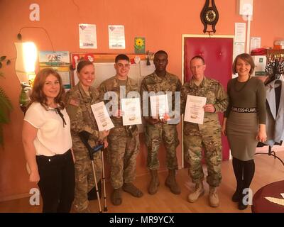 Le Sgt. Kayla Otting (de gauche), SPC. Austin Martel, la FPC. Darren Rowe et le sergent. Kenneth Matthews, tous les soldats de la Compagnie de soutien de l'avant Fox, 3e Bataillon, 29e Régiment d'artillerie, 3ème Armored Brigade Combat Team, 4e Division d'infanterie, recevoir des certificats d'appréciation de la part des enseignants à Zagan, Pologne, à la suite d'une visite avec les élèves du primaire le 24 avril 2017. Le bataillon a mis l'accent sur s'impliquer dans la communauté locale qu'il forme avec la 11e Division de cavalerie blindée polonaise dans le cadre de l'Europe de l'armée américaine Opération Atlantic résoudre. La mission strengthe Banque D'Images