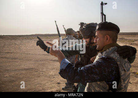 Un Guardia Civil espagnole formateur parle à un membre des forces de sécurité irakiennes au cours de formation au tir à courte portée à la gamme Besmaya complexe, l'Iraq, le 30 mai 2017. Cette formation fait partie de la Force opérationnelle interarmées combinée globale - Fonctionnement résoudre inhérent à renforcer les capacités des partenaires mission par la formation et de l'amélioration de la capacité des forces des combats en partenariat avec ISIS. Les GFIM-OIR est la Coalition mondiale pour vaincre ISIS en Iraq et en Syrie. (U.S. Photo de l'armée par le Cpl. Tracy McKithern) Banque D'Images