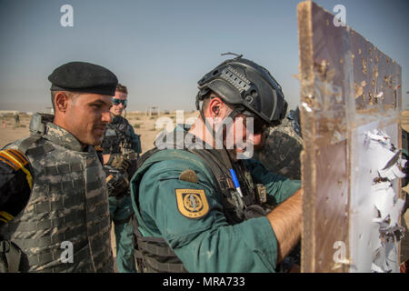 Un Guardia Civil espagnole formateur et un membre des forces de sécurité irakiennes vérifier une cible au cours de formation au tir à courte portée à la gamme Besmaya complexe, l'Iraq, le 30 mai 2017. Cette formation fait partie de la Force opérationnelle interarmées combinée globale - Fonctionnement résoudre inhérent à renforcer les capacités des partenaires mission par la formation et de l'amélioration de la capacité des forces des combats en partenariat avec ISIS. Les GFIM-OIR est la Coalition mondiale pour vaincre ISIS en Iraq et en Syrie. (U.S. Photo de l'armée par le Cpl. Tracy McKithern) Banque D'Images