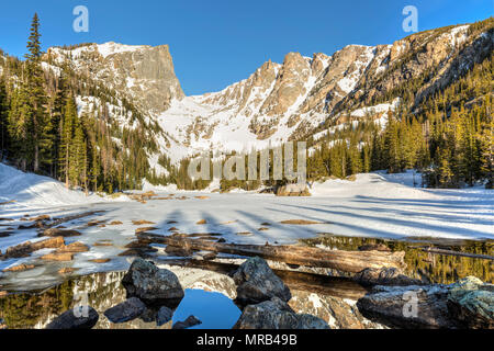 Soleil du matin sur pic Hallett est reflétée dans la moitié dans le lac gelé Dream Rocky Mountain National Park, Colorado Banque D'Images