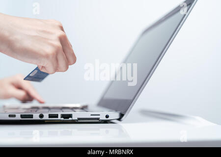 Mains tenant et de carte de crédit à l'aide de l'ordinateur portable. Magasinage en ligne Banque D'Images