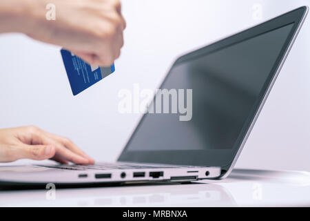 Mains tenant et de carte de crédit à l'aide de l'ordinateur portable. Magasinage en ligne Banque D'Images