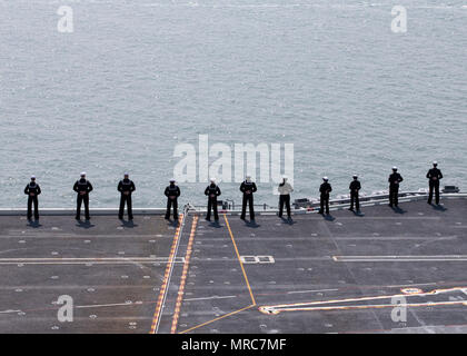 NORFOLK, Virginie (14 avril 2017) -- Les marins affectés à l'unité Pre-Commissioning Gerald R. Ford (CVN 78) les rails que le navire entre dans le port. La première classe de navire -- le premier porte-avions américain nouveau design en 40 ans - a passé plusieurs jours à la réalisation d'essais en mer du constructeur, un test complet de bon nombre des principaux systèmes du navire et des technologies. Banque D'Images