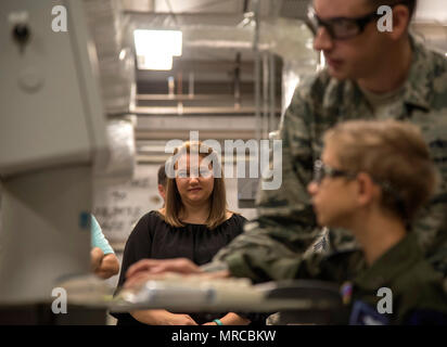 Brandy Flippo, mère d'Aidan Flippo, regarde Aidan, pilote d'un jour candidat, trace un motif à être coupé en tôle 25 mai 2017, à la base aérienne d'Eglin, en Floride. Flippo a été choisi pour être la 33e Escadre de chasse est pilote d'un jour. Aidan est né avec la Dysplasie Septo optique quels effets les yeux et les reins. Au cours de sa journée, il a rencontré les pilotes de F-35, a visité un avion, a travaillé avec les responsables d'avions et bien plus encore. (U.S. Photo de l'Armée de l'air par le sergent. Peter Thompson) Banque D'Images