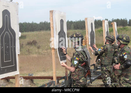 Pologne Groupe bataille soldats roumains examiner leurs cibles au cours d'une gamme de petit calibre menées près de la Bemowo Piskie Secteur d'entraînement pendant la grève de sabre 17 Juin 6. Grève 17 Sabre de l'armée américaine est une force multinationale de l'Europe exercer des forces combinées menée chaque année pour renforcer l'alliance de l'OTAN dans la région de la Baltique et de la Pologne. L'exercice de cette année comprend et intégré de formation axés sur la dissuasion synchronisé conçu pour améliorer l'interopérabilité et à l'état de préparation des forces militaires des Nations Unies participantes 20. (U.S. Photo de l'armée par le Sgt. Jimmy Golden/ libéré) Banque D'Images