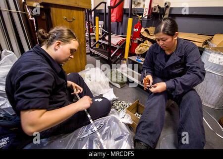 170605-N-UK248-0111 (5 juin 2017) Seaman Lea Sabino (droite), originaire des Philippines, et Seaman, Christina Cook, originaire de Cornwallville, New York, tous deux assignés à pont à bord du navire d'assaut amphibie USS America (LHA 6), l'étiquette des batteries pour l'expiration dans le cadre de leur entretien sur les gilets, dans l'un des garage du navire dans les baies de l'arrimage du véhicule inférieur. L'Amérique est actuellement en cours d'exercice de Certification (CERTEX) dans le cadre de la troisième et dernière phase des qualifications pour leur déploiement à venir. L'Amérique du groupe amphibie est composé de plus de t Banque D'Images