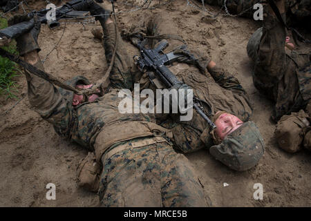 U.S. Marine Corps Ecr. Joshua Lundy, peloton 1045, Delta Entreprise, 1er Bataillon, et ECR. Emily Valley, peloton 4022, Papa Company, 4e Bataillon, Régiment d'entraînement des recrues, ramper sous les barbelés au cours de formation de base sur le Guerrier du Corps des marines de l'Île Parris, dépôt de recrues, L.C. (le 6 juin 2017. Guerrier de base formation est conçue pour enseigner l'importance du travail d'équipe, travailler sous le stress et la façon d'effectuer tout en utilisant de petits dirigeants de l'unité. (U.S. Marine Corps photo par le Cpl. Richard Currier/libérés) Banque D'Images