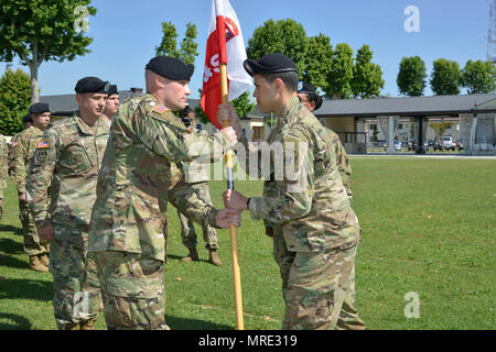 Le capitaine Joseph Mme Veary, droite, commandant de l'intelligence et au soutien de l'entreprise, l'Afrique de l'armée américaine, fait passer le guidon au 1er Sgt. Tchad N. blessé, Centre, Première les Sergent de J&S, société au cours d'une cérémonie de changement de responsabilité à Caserma Ederle à Vicenza, Italie, le 9 juin 2017. (U.S. Photo de l'armée par Visual Spécialiste de l'information Antonio Bedin/libérés) Banque D'Images